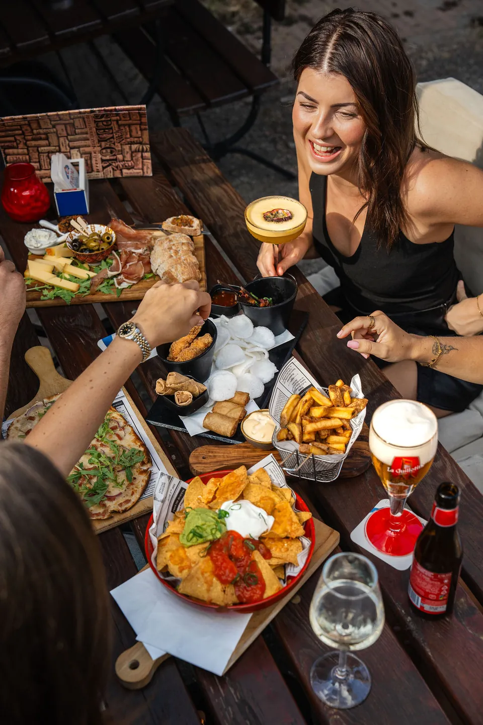 Gasten aan tafel met borrelhapjes en een speciaalbier